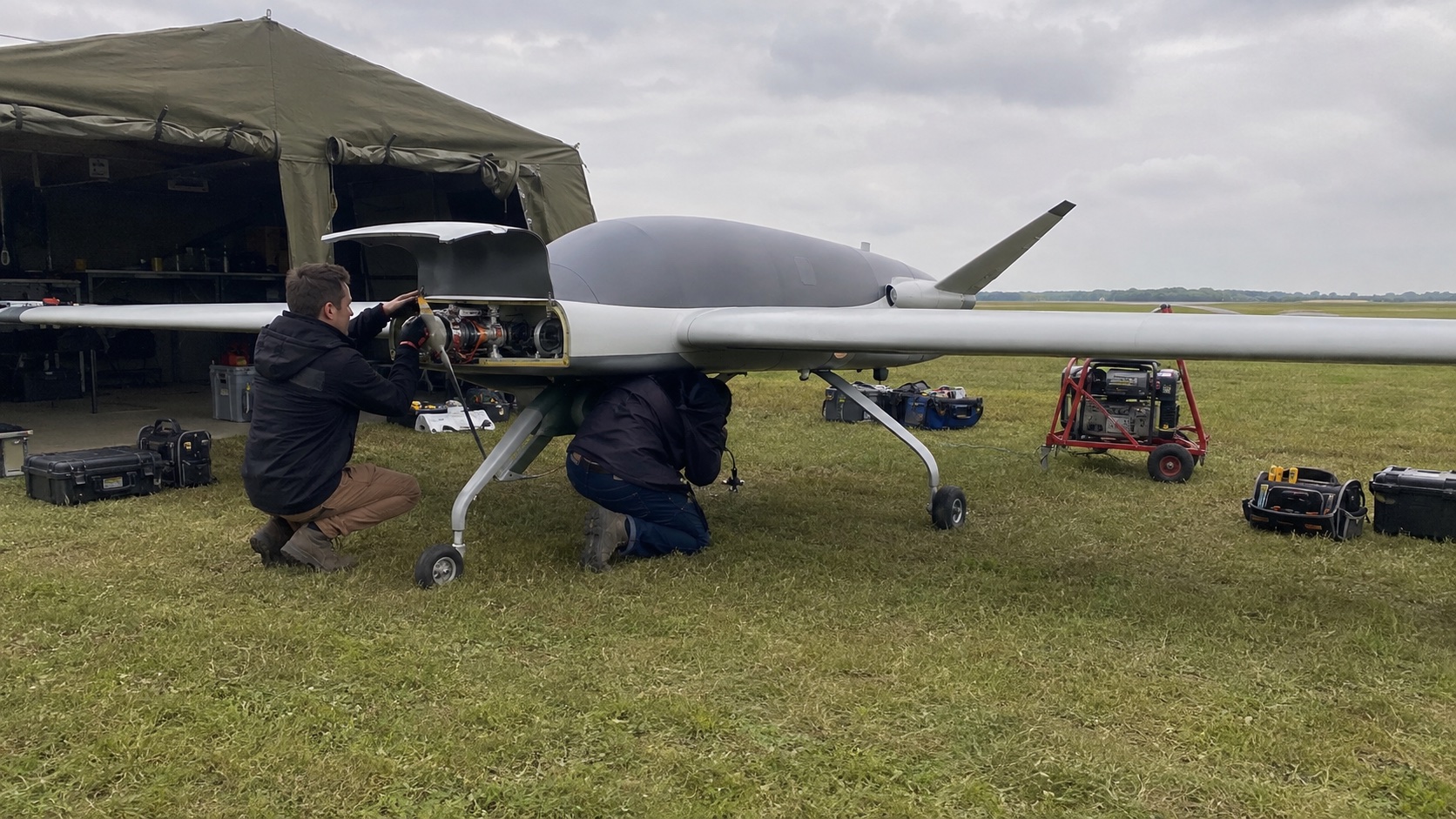Engineers preparing a long-endurance electric aircraft at a field site